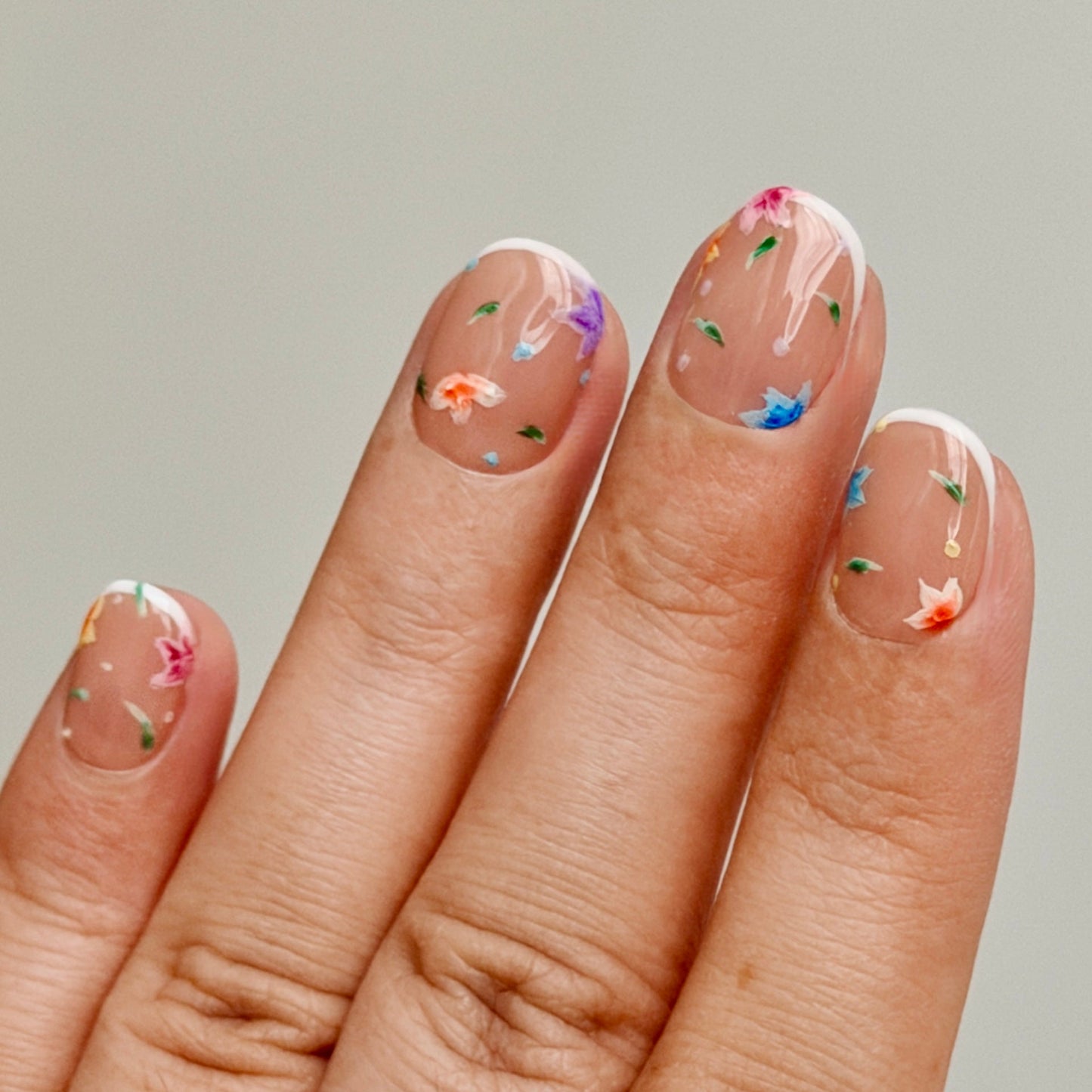 Nails with floral designs on a neutral background