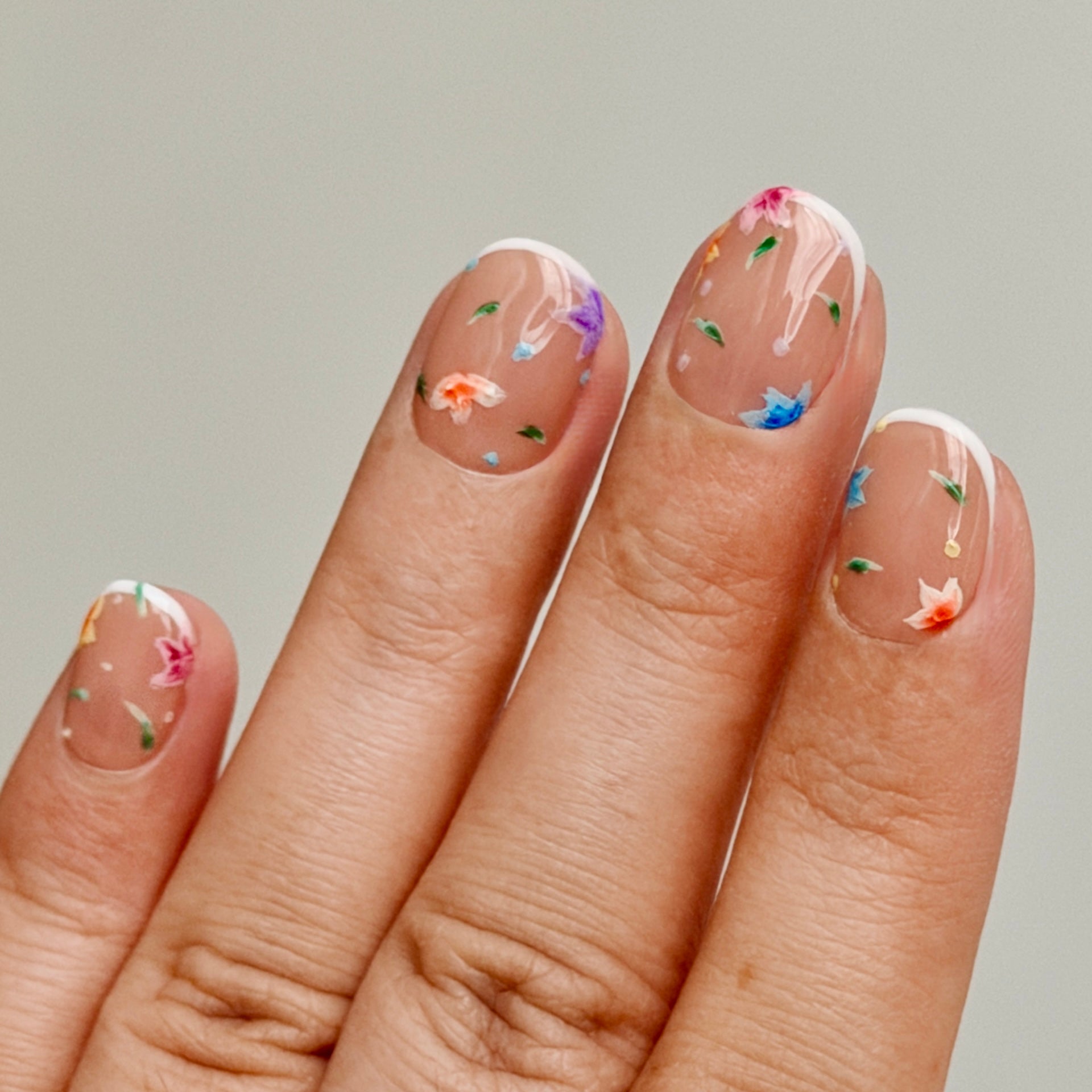 Nails with floral designs on a neutral background