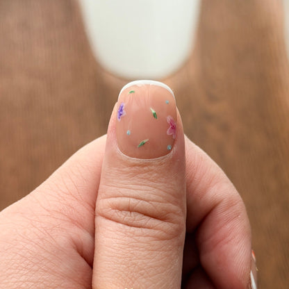 Close-up of a hand wearing a gold ring on a wooden surface