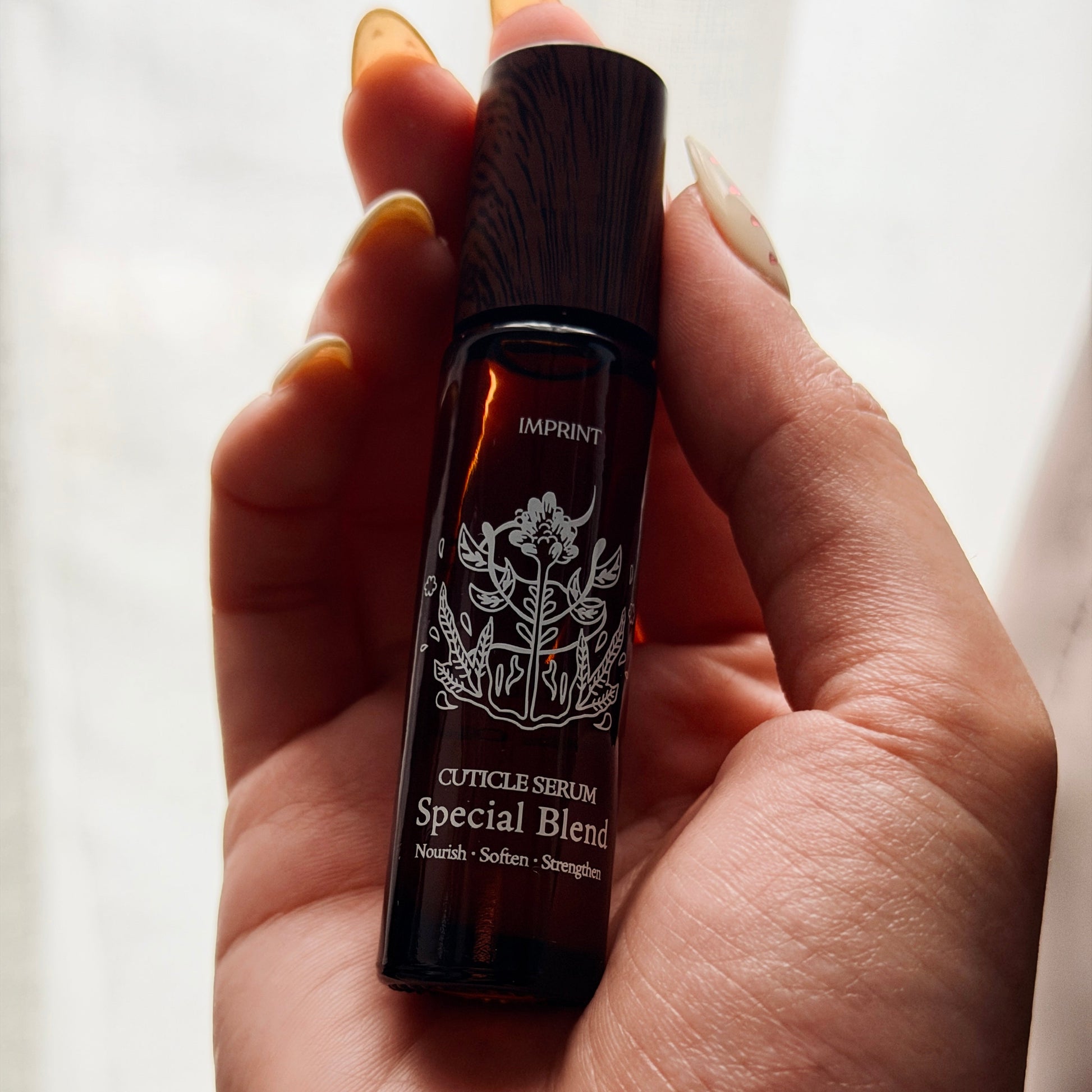Hand holding a small bottle labeled 'Special Blend' against a neutral background